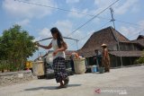 Petugas Badan Penanggulangan Bencana Daerah (BPBD) menyalurkan air bersih di Dusun Randu Rejo, Desa Marmoyo, Kecamatan Kabuh, Jombang, Jawa Timur, Kamis (15/8/2019). Setelah mendapatkan laporan permintaan air bersih oleh warga, BPBD Jombang melakukan droping air bersih sebanyak 5 ribu liter di wilayah setempat untuk kebutuhan memasak, minum dan mandi karena mereka kesulitan air bersih akibat dilanda kekeringan sejak beberapa bulan lalu. Antara jatim/Syaiful Arif/zk