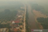 Foto udara kawasan permukiman penduduk yang diselimuti kabut asap di Arang-arang, Kumpeh Ulu, Muarojambi, Jambi, Kamis (15/8/2019). Desa Arang-arang merupakan satu dari dua desa terdekat atau berjarak sekitar 8 kilometer dengan sumber api kebakaran hutan dan lahan (Karhutla) gambut di wilayah Kumpeh Ulu yang terdampak kabut asap. ANTARA FOTO/Wahdi Septiawan/pras.