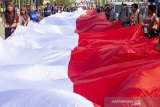 Warga membawa bendera merah putih raksasa saat memperingati peristiwa 16 Agustus 1945 di Rengasdengklok, Karawang, Jawa Barat, Jumat (16/8/2019). Pawai bendera raksasa tersebut mengiring bendera berukuran 16 meter, 8 meter dan 45 meter berkeliling Rengasdengklok untuk memperingati peristiwa 16 Agustus 1945. ANTARA FOTO/M Ibnu Chazar/agr