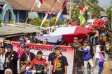 Warga membawa bendera merah putih raksasa saat memperingati peristiwa 16 Agustus 1945 di Rengasdengklok, Karawang, Jawa Barat, Jumat (16/8/2019). Pawai bendera raksasa tersebut mengiring bendera berukuran 16 meter, 8 meter dan 45 meter berkeliling Rengasdengklok untuk memperingati peristiwa 16 Agustus 1945. ANTARA FOTO/M Ibnu Chazar/agr