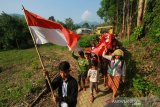 Warga dayak meratus berjalan menuju desa dengan membawa bendera merah putih dalam rangka memeriahkan HUT ke-74 Kemerdekaan RI di Desa Kiyu, Kabupaten Hulu Sungai Tengah, Kalimantan Selatan, Sabtu (17/8/2019).Selain merayakan HUT ke-74 Tahun Republik Indonesia, aksi tersebut digelar untuk kampanye Save Meratus.Foto Antaranews Kalsel/Bayu Pratama S.