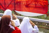 Sejumlah siswa sekolah mengikuti upacara bendera di Jembatan Cisomang, Purwakarta, Jawa Barat, Sabtu (17/8/2019). Bendera Merah Putih dengan ukuran 20 meter x 13 meter tersebut dikibarkan oleh tim gabungan pecinta alam Cimahi - Bandung Barat yang digagas oleh Mapala Janabona-IMT dalam rangka memperingati HUT-74 Kemerdekaan Republik Indonesia. ANTARA JABAR/M Ibnu Chazar/agr