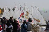 Warga menyaksikan Festival Perahu Layar di Kenjeran, Surabaya, Jawa Timur, Minggu (18/8/2019). Festival yang diikuti puluhan perahu layar itu dalam rangka memperingati  HUT ke-74 Kemerdekaan Republik Indonesia. Antara Jatim/Didik Suhartono/ZK