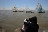 Warga menyaksikan Festival Perahu Layar di Kenjeran, Surabaya, Jawa Timur, Minggu (18/8/2019). Festival yang diikuti puluhan perahu layar itu dalam rangka memperingati  HUT ke-74 Kemerdekaan Republik Indonesia. Antara Jatim/Didik Suhartono/ZK