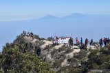 Pendaki mengibarkan bendera Merah Putih sambil menyanyikan lagu kebangsaan Indonesia Raya saat memperingati Hari Ulang Tahun ke-74 Proklamasi Kemerdekaan RI di kawasan Puncak Gunung Lawu Magetan, Jawa Timur, Sabtu (17/8/2019). Ribuan pendaki dari berbagai daerah mendaki puncak Gunung Lawu guna memperingati HUT ke-74 Proklamasi Kemerdekaan RI pada Sabtu 17 Agustus 2019. Antara Jatim/Siswowidodo/zk.