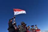 Pendaki mengibarkan bendera Merah Putih sambil menyanyikan lagu kebangsaan Indonesia Raya saat memperingati Hari Ulang Tahun ke-74 Proklamasi Kemerdekaan RI di kawasan Puncak Gunung Lawu Magetan, Jawa Timur, Sabtu (17/8/2019). Ribuan pendaki dari berbagai daerah mendaki puncak Gunung Lawu guna memperingati HUT ke-74 Proklamasi Kemerdekaan RI pada Sabtu 17 Agustus 2019. Antara Jatim/Siswowidodo/zk.