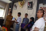 Kepala Dinas Perpustakaan dan Kearsipan Aceh, Wildan (kiri) menerima buku berjudul Bingkai Anak Negeri dari Siswa Mengenal Nusantara (SMN) provinsi Banten saat kunjungan di Kantor Kearsipan Aceh, Banda Aceh, Senin (19/8/2019). Buku Bingkai Anak Negeri terbitan tahun 2018 itu berisi testimoni pelajar seluruh provinsi di Indonesia dalam program Siswa Mengenal Nusantara (SMN) yang digagas Kementerian BUMN. Antara Aceh/Ampelsa.