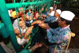 Sejumlah orang menyambut kedatangan jamaah haji asal Banjarmasin dan Hulu Sungai Selatan di Asrama Haji Debarkasi Banjarmasin, Banjarbaru, Kalimantan Selatan, Selasa (20/8/2019).Sebanyak 318 jamaah haji kloter pertama asal Banjarmasin dan Hulu Sungai Selatan serta enam jamaah haji tambahan yang di pulangkan lebih cepat karena kondisi kesehatan tiba di Asrama haji Debarkasi Banjarmasin.Foto Antaranews Kalsel/Bayu Pratama S.