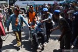 Sejumlah orang menyambut kedatangan jamaah Haji asal Kota Madiun di Asrama Haji Kota Madiun, Jawa Timur, Senin (19/8/2019). Menurut petugas, jumlah jamaah haji asal Kota Madiun yang berangkat melalui embarkasi Surabaya sebanyak 198 orang dan pulang dalam jumlah sama dalam kondisi sehat. Antara Jatim/Siswowidodoz/zk