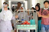 Petugas medis membawa Aqila ke Instalansi Rawat Inap (Irna) anak RSUD Dr Soetomo Surabaya, Jawa Timur, Selasa (20/8/2019). Aqila yang merupakan bayi kembar siam asal Kendari, Sulawesi Tenggara yang telah dilakukan operasi pemisahan dengan Azila itu dipindahkan dari Gedung Bedah Pusat Terpadu (GBPT) RSUD Dr Soetomo Surabaya ke Instalansi Rawat Inap (Irna) anak RSUD Dr Soetomo Surabaya karena dinyatakan dalam kondisi sehat oleh Tim Penanganan Bayi Kembar Siam RSUD Dr Soetomo. Antara Jatim/Didik Suhartono/ZK