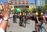 Penonton melambaikan tangan pada pebalap sepeda partisipan saat Start Etape Ketiga Tour De Indonesia di depan Jatim Park 3, Batu, Jawa Timur, Rabu (21/8/2019). tape ketiga tersebut merupakan jarak terjauh dari semua etape Tour de Indonesia yakni 193 kilometer dengan rute Kota Batu-Jember . Antara Jatim/Ari Bowo Sucipto/zk