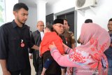 Terdakwa mantan Bupati Simeulue, Kabupaten Simeulue, Aceh, Darmili (tengah) menggendong cucunya seusai menghadiri sidang perdana di Pengadilan Negeri Tindak Pidana Korupsi, Banda Aceh, Aceh, Rabu (21/9/2019). Sidang perdana mantan Bupati Simeulue, Darmili tersebut mendengarkan dakwaan jaksa penutut umum dalam kasus dugaan korupsi penyertaan modal usaha pada Perusahaan Daerah Kabupaten Simeulue (PDKS) di bidang perkebunan kelapa sawit yang merugikan negara sebesar Rp5 miliar. Antara Aceh/Ampelsa.