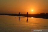 Wisatawan melakukan swafoto dengan latar belakang matahari tenggelam di kawasan Wisata Pantai Barat Pangandaran, Jawa Barat, Selasa (20/8/2019). Pada 2019, Kementerian Pariwisata optimis dapat mencapai target kunjungan 18 juta wisatawan asing, meskipun hingga Mei 2019 jumlah wisatawan yang datang baru 35 persen, sehingga peningkatan turis asing merupakan salah satu indikator yang baik bagi pertumbuhan sektor pariwisata Indonesia. ANTARA JABAR/Adeng Bustomi/agr