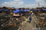 Warga melintas di puing rumah pasca kebakaran di Alalak Selatan, Banjarmasin, Kalimantan Selatan, Minggu (25/8/2019).Pasca kebakaran yang melanda kawasan tersebut pada Rabu (21/8/2019) sore, sejumlah warga masih mengungsi di tenda darurat akibat kehilangan tempat tinggal.Foto Antaranews Kalsel/Bayu Pratama S.