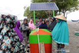 Staf Advokasi Kebijakan Energi Terbarukan WWF Indonesia wilayah Aceh Nanda Mariska (tiga kiri) memberikan pengarahan tentang alat pengolahan garam dengan tenaga surya kepada para petani garam tradisional di Lampanah, Aceh Besar, Aceh, Senin (26/8/2019). WWF Indonesia bekerjasama dengan Aceh Geothermal Forum (AGF) mengembangkan model produksi garam berbasis sinar surya yang diharapkan dapat meningkatkan mutu dan produksi garam. Antara Foto / Irwansyah Putra.