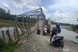 Pengendara sepeda motor melintasi Jembatan Ulee Rakeet yang miring dan rusak di lintas Meulaboh-Pante Ceureumen, Desa Sawang Teubee, Kecamatan Kaway XVI, Kabupaten Aceh Barat, Rabu (28/8/2019). Meski rusak dan mengancam keselamatan namun warga masih melintasinya. Antara Aceh / Teuku Dedi Iskandar.