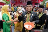 Wali Kota Banda Aceh Aminullah Usman (dua kanan) memperlihatkan kelapa yang telah dikukur setelah mengikuti lomba mengukur kelapa tradisional di lapangan bekas Hotel Atjeh, Banda Aceh, Aceh, Rabu (28/8/2019). Lomba mengukur kelapa sebagai salah satu upaya melestarikan dan membudayakan kembali peralatan kukur tradisional yang sudah mulai jarang digunakan. Antara Aceh / Irwansyah Putra.