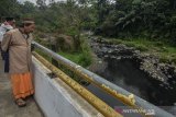 Warga mengamati Sungai Cisaruni yang diduga tercemar limbah di Kampung Sukarame, Kabupaten Tasikmalaya, Jawa Barat, Rabu (28/8/2019).  Kondisi air aliran Sungai Cisaruni yang bermuara ke Sungai Ciwulan tersebut berubah warna dan mengeluarkan bau yang diduga akibat limbah industri sehingga menganggu aktivitas warga di sekitar sungai tersebut. ANTARA JABAR/Adeng Bustomi/agr