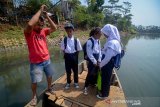 Sejumlah siswa SMPN Baleendah II menyeberangi Sungai Citarum menggunakan perahu eretan di Bojongsoang, Kabupaten Bandung, Jawa Barat, Rabu (28/8/2019). Menko Bidang Kemaritiman Luhut Binsar Panjaitan menyatakan, program Citarum Harum di tiga sektor telah mencapai 60 persen dan ditargetkan akan pulih pada 2025 mendatang. ANTARA JABAR/Raisan Al Farisi/agr