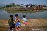 Sejumlah anak memperhatikan alat berat yang mengeruk Sungai Citarum di Bojongsoang, Kabupaten Bandung, Jawa Barat, Rabu (28/8/2019). Menko Bidang Kemaritiman Luhut Binsar Panjaitan menyatakan, program Citarum Harum di tiga sektor telah mencapai 60 persen dan ditargetkan akan pulih pada 2025 mendatang. ANTARA JABAR/Raisan Al Farisi/agr