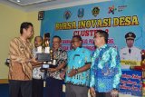 BURSA INOVASI DESA KABUPATEN MADIUN. Bupati Madiun Ahmad Dawami (kiri) menyerahkan piala kepada kepala desa pemenang lomba video potensi desa saat digelar Bursa Inovasi Desa di Desa Ngampel, Kecamatan Mejayan, Kabupaten Madiun, Jawa Timur, Kamis (29/8/2019). Bursa Inovasi Desa digelar untuk saling bertukar pikiran antardesa tentang inovasi desa. Antara Jatim/Siswowidodo