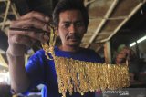 Perajin menyelesaikan pembuatan kerajinan perhiasan tembaga di Indramayu, Jawa Barat, Jumat (30/8/2019). Kerajinan perhiasan berbahan tembaga yang dilapisi emas tersebut kian diminati pasar dengan harga Rp20ribu per gram hingga Rp70 ribu per gram tergantung motif. ANTARA FOTO/Dedhez Anggara/agr