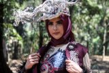 Model mengenakan busana rancangan desainer Lia Afif saat sesi foto di kawasan kebun raya Purwodadi, Pasuruan, Jawa Timur, Sabtu (31/8/2019). Lia Afif fashion designer menghadirkan 12 desain busana muslim dengan rangkaian busana Batik Tulis Kutai Timur nan Eksotik yang bertema 