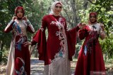 Model mengenakan busana rancangan desainer Lia Afif saat sesi foto di kawasan kebun raya Purwodadi, Pasuruan, Jawa Timur, Sabtu (31/8/2019). Lia Afif fashion designer menghadirkan 12 desain busana muslim dengan rangkaian busana Batik Tulis Kutai Timur nan Eksotik yang bertema 