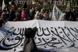 Massa yang tergabung dalam Forum Silaturahmi Muslim Bandung membawa bendera kalimat tauhid saat melakukan aksi unjuk rasa di depan Gedung Sate, Bandung, Jawa Barat, Minggu (1/9/2019). Aksi tersebut menuntut pemerintah Indonesia untuk segera menghilangkan keberadaan paham komunisme, sistem liberal dan kapitalis serta terus memperkuat ukhuwah islam di Indonesia dengan peringatan tahun baru islam 1441 Hijriah sebagai momentum perubahan. ANTARA FOTO/Novrian Arbi/agr