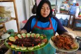 Warga memperlihatkan masakan gulai kepiting dan ikan bakar di Desa Pasir Putih, Bungatan, Situbondo, Jawa Timur, Minggu (1/9/2019). Menyambut perayaan Tahun Baru Islam 1 Muharram 1441 H, masyarakat pesisir Situbondo membuat sajian kuliner khas berupa, gulai kepiting, asam manis kepiting, ikan bakar, dan mi goreng cumi. Antara Jatim/Seno/zk.