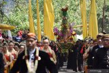 Sejumlah orang mengusung tumpeng dan gunungan terbuat dari rangkaian hasil bumi saat kirab gunungan di kawasan Telaga Ngebel, Ponorogo, Jawa Timur, Minggu (1/9/2019). Kirab gunungan dan tumpeng yang selanjutnya sebagian dilarung di Telaga Ngebel tersebut merupakan tradisi warga sekitar telaga dalam menyambut tahun baru Jawa 1 Sura bersamaan tahun baru Islam 1 Muharram sebagai ungkapan rasa syukur pada Tuhan YME. Antara Jatim/Siswowidodo/zk.