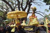 Sejumlah orang mengusung tumpeng dan gunungan terbuat dari rangkaian hasil bumi saat kirab gunungan di kawasan Telaga Ngebel, Ponorogo, Jawa Timur, Minggu (1/9/2019). Kirab gunungan dan tumpeng yang selanjutnya sebagian dilarung di Telaga Ngebel tersebut merupakan tradisi warga sekitar telaga dalam menyambut tahun baru Jawa 1 Sura bersamaan tahun baru Islam 1 Muharram sebagai ungkapan rasa syukur pada Tuhan YME. Antara Jatim/Siswowidodo/zk.