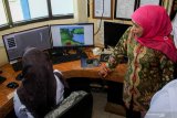 Gubernur Jawa Timur Khofifah Indar Parawansa (kanan) melihat alat operasional digital untuk pengamatan cuaca di kantor Badan Meteorologi Klimatologi dan Geofisika (BMKG) Juanda, Sidoarjo, Jawa Timur, Senin (2/9/2019). Pemerintah Provinsi Jawa Timur meminta Badan Meteorologi Klimatologi dan Geofisika (BMKG) tingkatkan koordinasi dengan Badan Penanggulangan Bencana Daerah (BPBD) dan Komite Nasional Keselamatan Transportasi (KNKT) terkait masalah cuaca di jawa timur yang tidak hujan selama 60 hari karena BMKG memprediksi awal musim hujan akan jatuh pada akhir November 2019 hingga awal Desember 2019. Antara Jatim/Umarul Faruq/zk