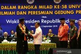 Rektor Universitas Syiah Kuala (Unsyiah) Banda Aceh Samsul Rizal (kiri) menyerahkan bingkisan dan plakat kepada Wakil Presiden Republik Indonesia Jusuf Kalla (dua kiri) pada sidang terbuka dalam rangka milad ke-58 Unsyiah di degung AAC Dayan Dawood, Banda Aceh, Aceh, Senin (2/9/2019). Pada milad Unsyiah itu Wakil Presiden juga memberikan orasi ilmiah dihadapan civitas akademika dan peresmian gedung project 7in1. Antara Aceh / Irwansyah Putra.