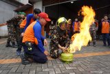 Seorang peserta Pendidikan dan Pelatihan Khusus Banser Relawan Kebakaran (Diklatsus Balakar) didampingi Komandan Pemadam Kebakaran Panca Bhakti Edi Lin (tiga kiri) belajar cara memadamkan api dari tabung gas di Markas Damkar PB di Pontianak, Kalimantan Barat, Minggu (1/9/2019). Dalam Diklatsus Balakar yang digelar Satkorwil Banser Kalbar dan Damkar Panca Bhakti tersebut peserta belajar tentang cara menanggulangi kebakaran yang terjadi di pemukiman warga. ANTARA FOTO/Jessica Helena WuysangANTARA FOTO/JESSICA HELENA WUYSANG (ANTARA FOTO/JESSICA HELENA WUYSANG)