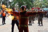 Sejumlah peserta Pendidikan dan Pelatihan Khusus Banser Relawan Kebakaran (Diklatsus Balakar) menyaksikan ujicoba api pada ketahanan baju pemadam kebakaran di Yayasan Damkar PB di Pontianak, Kalimantan Barat, Minggu (1/9/2019). Dalam Diklatsus Balakar yang digelar Satkorwil Banser Kalbar dan Damkar Panca Bhakti tersebut peserta belajar tentang cara menanggulangi kebakaran yang terjadi di pemukiman warga. ANTARA FOTO/Jessica Helena WuysangANTARA FOTO/JESSICA HELENA WUYSANG (ANTARA FOTO/JESSICA HELENA WUYSANG)