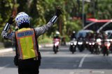 Polisi mengarahkan pengendara motor saat Operasi Patuh Semeru 2019 di Jalan Darmo, Surabaya, Jawa Timur, Selasa (3/9/2019). Lima hari sejak digelarnya Operasi Patuh Semeru 2019, Satlantas Polrestabes Surabaya dan unit lantas polsek jajaran telah menindak tilang sekitar 9.006 pelanggar lalulintas yang didominasi dengan pelanggaran melawan arus, tidak memiliki SIM serta melanggar rambu-rambu lalulintas. Antara Jatim/Didik Suhartono/ZK