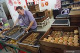 Pemilik usaha pembuatan kue Hong Hak Anthony Chen memperlihatkan sejumlah loyang berisi kue bulan yang diproduksinya di Jalan Gajahmada, Pontianak, Kalimantan Barat, Minggu (1/9/2019). Kue Bulan khas Pontianak yang merupakan salah satu hidangan wajib saat perayaan kue bulan tersebut diproduksi oleh Hong Hak sejak tahun 1936 dan dipasarkan seharga Rp160 ribu hingga Rp180 ribu per kotak di Indonesia dan mancanegara. ANTARA FOTO/Jessica Helena WuysangANTARA FOTO/JESSICA HELENA WUYSANG (ANTARA FOTO/JESSICA HELENA WUYSANG)