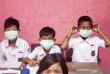 Sejumlah siswa memakai masker yang diberikan oleh petugas medis di SDN 1 Cemarajaya, Karawang, Jawa Barat, Selasa (3/9/2019). Pertamina bersinergi bersama Pertamedika memberikan pelayanan kesehatan gratis dan membagikan masker serta mengedukasi siswa berupa penyuluhan tentang menjaga kebersihan dan kesehatan di wilayah terdampak tumpahan minyak mentah. ANTARA FOTO/M Ibnu Chazar/agr