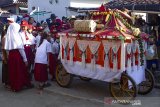 Sejumlah siswa sekolah dasar melihat dongdang yang diarak saat tradisi hajat bumi di Desa Cemarajaya, Karawang, Jawa Barat, Selasa (3/9/2019). Tradisi tersebut dilakukan dalam tiga tahun sekali dalam kepercayaan warga pesisir laut utara untuk menolak bala dan sebagai rasa bersyukur atas rezeki melalui hasil bumi yang diberikan Tuhan. ANTARA FOTO/M Ibnu Chazar/agr