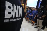 Petugas Badan Narkotika Nasional Provinsi (BNNP) Jawa Timur menunjukkan tersangka pengedar narkoba jenis sabu di sela-sela acara pemusnahan barang bukti narkoba di Surabaya, Jawa Timur, Selasa (3/9/2019). BNNP Jawa Timur memusnahkan 24.454 gram sabu-sabu dari dua tempat kejadian perkara yang berbeda serta mengamankan empat orang tersangka berinisial FR, IW, HS dan AS. Antara Jatim/Moch Asim/zk.