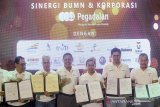 KOLABORASI PROGRAM LAYANAN BUMN. Direktur Utama PT Pegadaian (Persero) Kuswiyoto (ketiga kiri) bersama Direktur Operasi II PT LEN, Adi Sufiadi Yusuf (kiri), Direktur SDM PT Bio Farma, Disril Revolin Putra (kedua kiri), dan Direktur Jaringan dan Layanan Keuangan PT Pos, Ihwan Sutardiyanta (ketiga kanan) menunjukan nota kesepahaman yang telah ditandatangani saat acara kolaborasi program layanan BUMN di Bandung, Jawa Barat, Kamis (5/9/2019). PT Pegadaian (Persero) berkolaborasi dengan 7 BUMN dan 14 perusahaan swasta dan UKM di Bandung sebagai salah satu upaya mewujudkan inklusi layanan industri keuangan Indonesia di era 