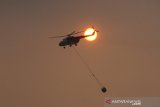 Helikopter milik Badan Nasional Penanggulangan Bencana (BNPB) melakukan water bombing pada kebakaran lahan gambut di Desa Pengayuan, Kecamatan Liang Anggang, Banjarbaru, Kalimantan Selatan, Jumat (6/9/2019).Ratusan hektar lahan gambut di kawasan Liang Anggang terbakar hingga mendekati permukiman penduduk di wilayah setempat.Foto Antaranews Kalsel/Bayu Pratama S.