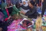 Seorang tokoh adat berdoa untuk warga yang kesurupan saat tradisi babaritan di Kampung Guro III, Desa Karawang Wetan, Karawang, Jawa Barat, Sabtu (7/9/2019). Tradisi tersebut dilakukan untuk menjaga dan melestarikan tradisi leluhur sebagai bentuk rasa bersyukur atas rezeki melalui seluruh kekayaan hasil bumi dari darat, laut dan udara yang diberikan Tuhan. ANTARA FOTO/M Ibnu Chazar/agr