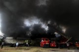 Petugas Dinas Pemadam Kebakaran Kota Surabaya memadamkan gudang yang terbakar di Margomulyo Indah, Surabaya, Jawa Timur, Minggu (8/9/2019). Sekitar 23 kendaraan pemadam kebakaran dikerahkan untuk memadamkan api yang membakar gudang onderdil kendaraan bermotor itu. Antara Jatim/Didik Suhartono/zk