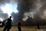 Petugas Dinas Pemadam Kebakaran Kota Surabaya memadamkan gudang yang terbakar di Margomulyo Indah, Surabaya, Jawa Timur, Minggu (8/9/2019). Sekitar 23 kendaraan pemadam kebakaran dikerahkan untuk memadamkan api yang membakar gudang onderdil kendaraan bermotor itu. Antara Jatim/Didik Suhartono/zk