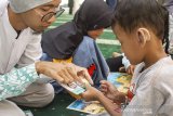 Pengajar menjelaskan kisah-kisah nabi menggunakan papan permainan kepada anak penyandang tuli saat pelatihan kisah dalam isyarat di Masjid Baitul Falihin, Karawang, Jawa Barat, Minggu (8/9/2019). Pelatihan yang diselenggarakan oleh Komunitas Anak Tangguh Karawang bekerja sama dengan The Little Hijabi Homeschooling dan Qur'an Indonesia Project tersebut digelar untuk memperkenalkan serta mengajarkan pengetahuan tentang Islam bagi penyandang tuli dengan mengunakan bahasa isyarat. ANTARA FOTO/M Ibnu Chazar/agr