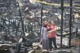 Warga mengamati rumah-rumah yang hangus dan runtuh akibat kebakaran di kawasan Alalak Selatan, Banjarmasin, Kalimantan Selatan, Selasa (10/9/2019). Sebanyak 65 rumah hangus terbakar di permukiman padat penduduk tersebut, dimana penyebab kebakaran diduga akibat korsleting listrik. Foto Antaranews Kalsel/Bayu Pratama S.