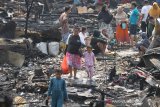 Warga melintas di rumah-rumah yang hangus dan runtuh akibat kebakaran di kawasan Alalak Selatan, Banjarmasin, Kalimantan Selatan, Selasa (10/9/2019). Sebanyak 65 rumah hangus terbakar di permukiman padat penduduk tersebut, dimana penyebab kebakaran diduga akibat korsleting listrik. Foto Antaranews Kalsel/Bayu Pratama S.