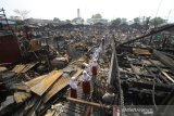 Warga mengamati rumah-rumah yang hangus dan runtuh akibat kebakaran di kawasan Alalak Selatan, Banjarmasin, Kalimantan Selatan, Selasa (10/9/2019). Sebanyak 65 rumah hangus terbakar di permukiman padat penduduk tersebut, dimana penyebab kebakaran diduga akibat korsleting listrik. Foto Antaranews Kalsel/Bayu Pratama S.